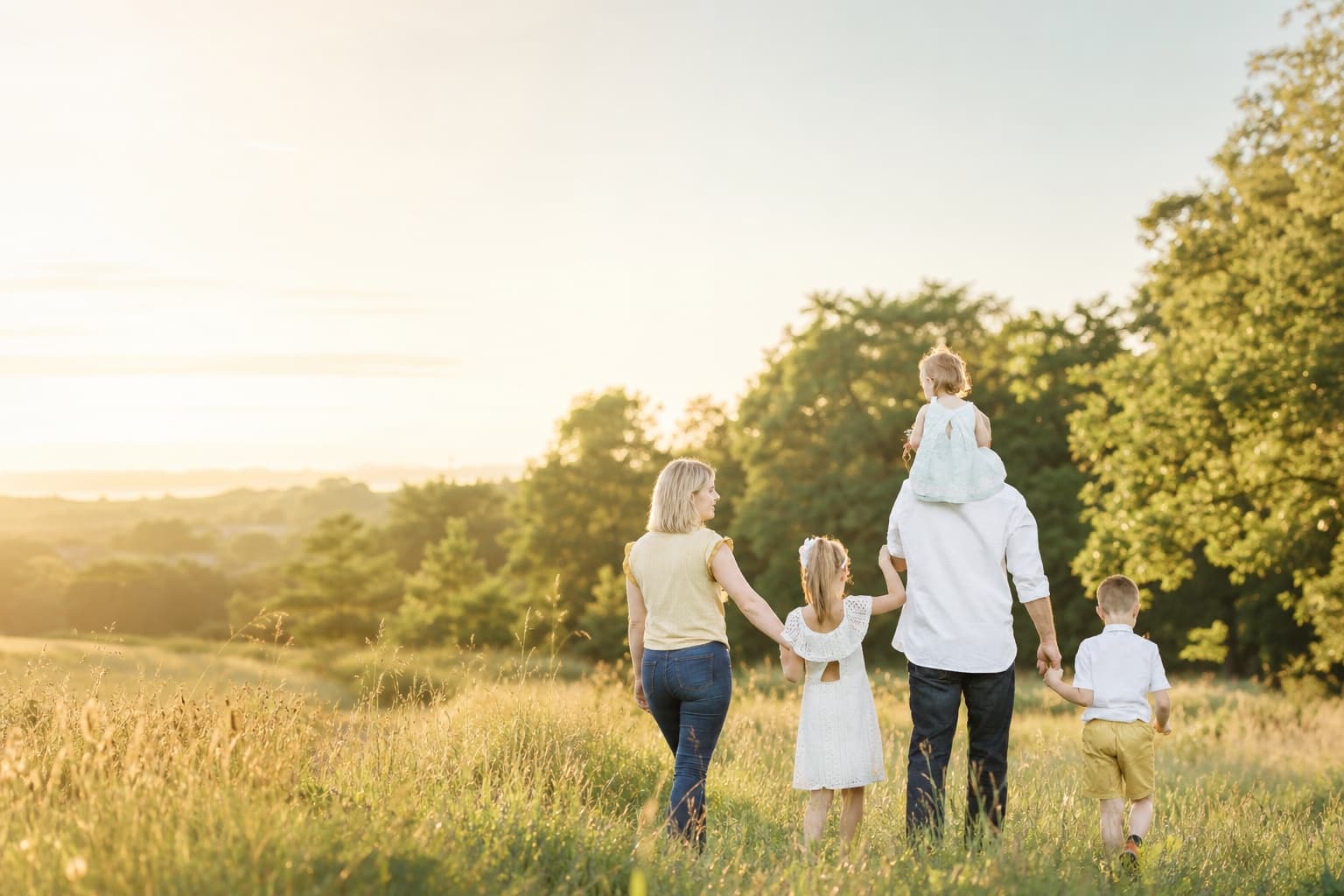A family walking together through a sunlit meadow, reflecting the life that thoughtful pension planning can support